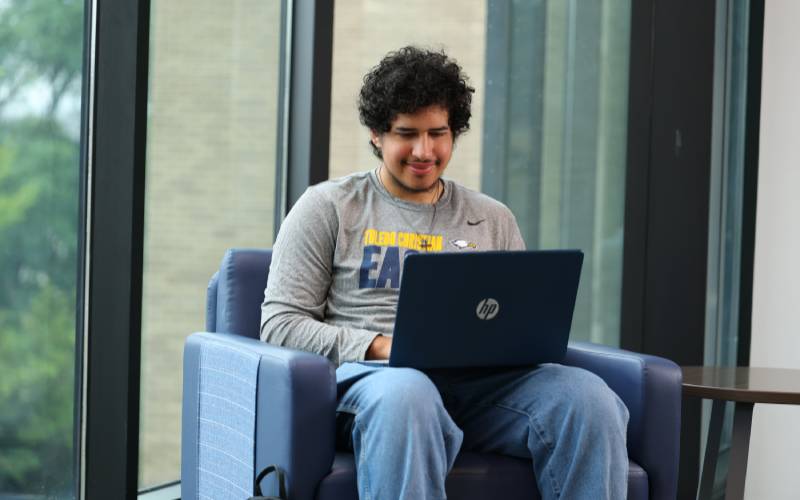 student sitting in UToledo Carlson Library