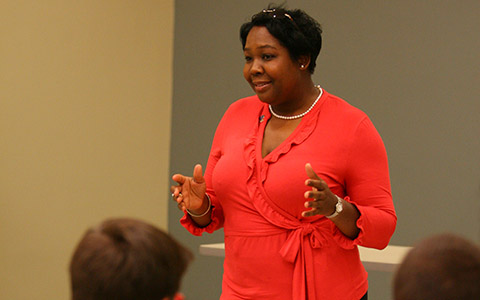 A woman speaks to an audience in a lecture hall